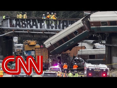 derailed amtrak train dangles over highway in washington