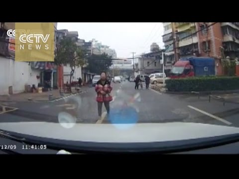 a woman pretending to be hit by a car on the streets of wuhan in hubei province